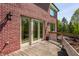 Exterior view of a brick house with a walkout deck surrounded by a lush lawn and greenery at 553 Bolderwood Ln, Carmel, IN 46032