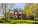 Charming brick two-story home with manicured lawn, arched entry, and lush landscaping at 553 Bolderwood Ln, Carmel, IN 46032