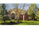 Charming brick two-story home with manicured lawn, arched entry, and mature landscaping at 553 Bolderwood Ln, Carmel, IN 46032