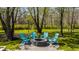 Outdoor firepit and chairs set in a lush, landscaped backyard, perfect for entertaining at 553 Bolderwood Ln, Carmel, IN 46032