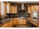 Well-lit kitchen with granite countertops, stainless steel appliances, and custom wooden cabinetry at 553 Bolderwood Ln, Carmel, IN 46032