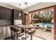 Modern outdoor kitchenette with stainless steel appliances, and a view of the pool and backyard at 553 Bolderwood Ln, Carmel, IN 46032