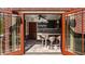 Outdoor kitchen area with French doors, sleek cabinets, bar seating, and stone flooring at 553 Bolderwood Ln, Carmel, IN 46032