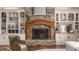 Cozy living room features a stone fireplace with wood mantel and custom built-in shelving and cabinets at 553 Bolderwood Ln, Carmel, IN 46032