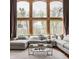 Comfortable living room featuring a large sectional sofa and expansive windows with wooded views at 553 Bolderwood Ln, Carmel, IN 46032