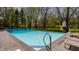 Backyard pool view showing privacy, trees, half basketball court, and relaxing chaise lounges at 553 Bolderwood Ln, Carmel, IN 46032