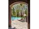 Framed view of a luxurious pool area with lounge chairs, and a basketball hoop, surrounded by mature trees at 553 Bolderwood Ln, Carmel, IN 46032