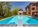 Beautiful swimming pool features diving board, lounge seating, and stunning views of backyard with attached home at 553 Bolderwood Ln, Carmel, IN 46032