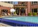 Stunning pool with blue tile, lounge chairs, basketball hoop, and a view of the home's elegant balcony at 553 Bolderwood Ln, Carmel, IN 46032