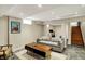 Finished basement with gray couch, wooden coffee table, gray tiled floors, and access to a staircase at 5611 N Delaware St, Indianapolis, IN 46220