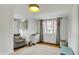 Bedroom with a light colored rug, gray chair, white dresser, and curtains hanging around the window at 5611 N Delaware St, Indianapolis, IN 46220