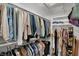 Walk-in closet with clothing on racks, suitcase, shelves with folded garments, and shoes at 5611 N Delaware St, Indianapolis, IN 46220