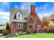 Charming red brick home with a classic design, beautiful landscaping, and inviting front porch at 5611 N Delaware St, Indianapolis, IN 46220