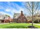 Charming brick Tudor-style home with a well-manicured lawn and blossoming trees at 5611 N Delaware St, Indianapolis, IN 46220