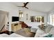 A living room bathed in natural light, featuring a ceiling fan, stylish rug, and a view of a staircase at 5611 N Delaware St, Indianapolis, IN 46220