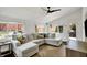 Bright living room featuring a ceiling fan, large windows offering views of the fenced backyard and an outdoor seating area at 5611 N Delaware St, Indianapolis, IN 46220