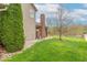 Side view of house shows well maintained lawn, brick chimney, and gravel landscaping at 5895 Sugar Pine Dr, Avon, IN 46123