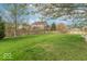 Large, green backyard enclosed by a wooden fence with mature trees at 5895 Sugar Pine Dr, Avon, IN 46123