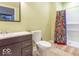 Well-lit bathroom featuring a shower with a colorful curtain, toilet, and vanity at 5895 Sugar Pine Dr, Avon, IN 46123