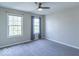 A cozy bedroom features neutral walls, gray carpet, and bright windows with natural light and a ceiling fan at 5895 Sugar Pine Dr, Avon, IN 46123