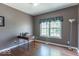 Cozy bedroom with hardwood floors, neutral walls, a vintage typewriter, and a bright window at 5895 Sugar Pine Dr, Avon, IN 46123