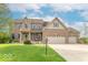 Traditional brick home with a three-car garage and well-manicured lawn at 5895 Sugar Pine Dr, Avon, IN 46123