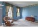 Cozy living room showcasing blue walls, floral wallpaper border, and soft carpet at 5895 Sugar Pine Dr, Avon, IN 46123