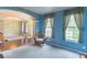 Inviting living room with bright blue walls, archways, a wicker chair, and large windows at 5895 Sugar Pine Dr, Avon, IN 46123