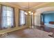 Open-concept living room featuring an archway, chandelier, and large windows offering an abundance of natural light at 5895 Sugar Pine Dr, Avon, IN 46123