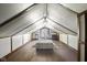 Finished attic with hardwood floors, a comfortable ottoman, and a window at the far end at 617 Carlyle Pl, Indianapolis, IN 46201