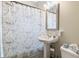 Bathroom with pedestal sink, decorative mirror, paisley print shower curtain and toilet at 617 Carlyle Pl, Indianapolis, IN 46201