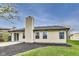 View of backyard, showcasing siding and a chimney, with nice landscaping, lawn and patio at 6218 Churchman Way, Indianapolis, IN 46237