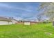 A view of the backyard, showcasing a well-maintained lawn, a storage shed, and a wooden fence at 6218 Churchman Way, Indianapolis, IN 46237