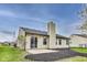 Backyard features chimney, sliding glass doors, small patio, lawn and dark mulch at 6218 Churchman Way, Indianapolis, IN 46237