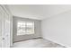 Cozy bedroom features a window, light gray walls, and gray wood floors at 6218 Churchman Way, Indianapolis, IN 46237