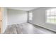 A bright bedroom with windows, light gray walls, and gray wood floors at 6218 Churchman Way, Indianapolis, IN 46237