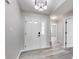 Inviting foyer with gray walls, light wood-look flooring, and a stylish modern light fixture at 6218 Churchman Way, Indianapolis, IN 46237