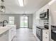 Modern kitchen with stainless steel appliances, granite countertops, and access to the backyard at 6218 Churchman Way, Indianapolis, IN 46237