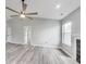 Bright living room with gray walls, ceiling fan, large window, and sleek modern flooring at 6218 Churchman Way, Indianapolis, IN 46237