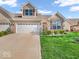 Charming brick townhome with a well-manicured front yard and a two-car garage at 6502 E Walton Dr, Camby, IN 46113