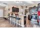 The open kitchen features dark wood cabinets, barstool seating, stainless appliances and hardwood flooring at 6502 E Walton Dr, Camby, IN 46113