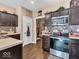 The updated kitchen features dark wood cabinets, stainless appliances and hardwood flooring at 6502 E Walton Dr, Camby, IN 46113