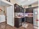 Updated kitchen boasts dark wood cabinets, stainless appliances and views to the laundry area at 6502 E Walton Dr, Camby, IN 46113