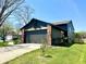 Side view of a charming home featuring a gray two-car garage and well-maintained landscaping at 653 Southridge Ct, Westfield, IN 46074