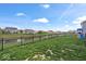 A large backyard features a black fence along the canal and a play set for  at 6536 W Shoreline Ct, Greenfield, IN 46140