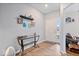 Bright entryway with hardwood floors, a glass console table, and tasteful wall decorations create a welcoming ambiance at 6536 W Shoreline Ct, Greenfield, IN 46140