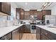 Stylish kitchen featuring stainless steel appliances, white countertops, and dark cabinets for a modern aesthetic at 6536 W Shoreline Ct, Greenfield, IN 46140