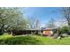 Charming single-story brick home with a well-manicured lawn and a covered front porch and beautiful blue skies at 6622 Stanley Rd, Camby, IN 46113