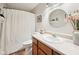 Bright bathroom featuring a vanity with wood cabinets, a round mirror and a shower with curtain at 6853 Arjay Dr, Indianapolis, IN 46217