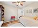 This cozy bedroom features hardwood floors, a ceiling fan, neutral walls and three framed artworks at 6853 Arjay Dr, Indianapolis, IN 46217